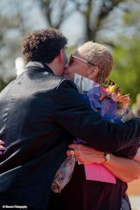 a man kisses a woman in front of a crowd